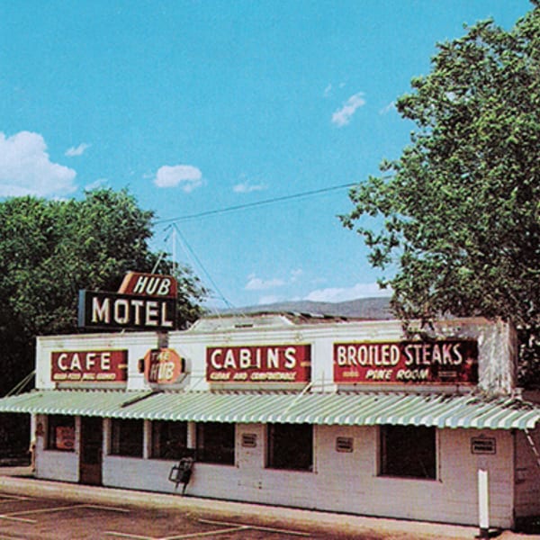 The Hub Motel and Cafe building with signs for "Cafe," "Cabins," and "Broiled Steaks."